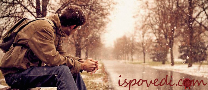 парень сидит в парке на лавочке